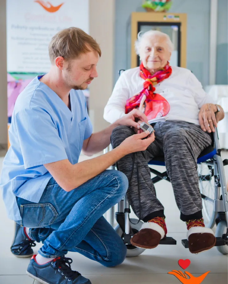 Opiekun medyczny rozmawiający z seniorką na wózku